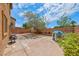 Spacious backyard features a concrete patio, brick fence, lush landscaping, and playhouse at 4421 Galapagos Ave, North Las Vegas, NV 89084