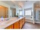 Bright bathroom with double sinks, soaking tub, walk-in shower, and wood-style flooring at 4421 Galapagos Ave, North Las Vegas, NV 89084