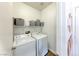 Functional laundry room with washer, dryer, shelving for storage, and great lighting at 4421 Galapagos Ave, North Las Vegas, NV 89084