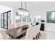 Bright dining room featuring modern chandelier, dark wood table, seating for eight, and neutral decor at 50 Grey Feather Dr, Las Vegas, NV 89135