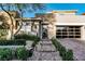 Stunning home featuring stone accents, mature landscaping, and a driveway leading to a glass-paneled garage at 50 Grey Feather Dr, Las Vegas, NV 89135