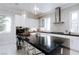 Spacious kitchen featuring a central island with bar seating and contemporary lighting fixtures at 50 Grey Feather Dr, Las Vegas, NV 89135
