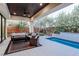 Covered outdoor living area with seating area, outdoor kitchen, and pool at 50 Grey Feather Dr, Las Vegas, NV 89135