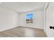 Bright bedroom featuring clean white walls and light wood flooring, with a window view of the neighborhood at 5030 E Hacienda Ave, Las Vegas, NV 89122