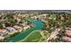 Scenic aerial view showcasing a golf course with a picturesque lake and surrounding homes at 5228 Painted Lakes Way, Las Vegas, NV 89149