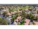 Aerial view showcases home's location with pool, landscaping, and golf course in the distance at 5228 Painted Lakes Way, Las Vegas, NV 89149