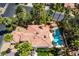 Aerial view of a private home featuring a red tile roof, backyard pool, and lush landscaping at 5228 Painted Lakes Way, Las Vegas, NV 89149