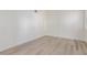 Empty bedroom with light hardwood floor and white walls with bright natural light at 5228 Painted Lakes Way, Las Vegas, NV 89149