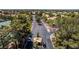 Aerial view of a community entrance with mature trees, landscaping, and gated access at 5228 Painted Lakes Way, Las Vegas, NV 89149