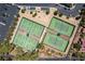 Aerial view showing tennis courts with lush landscaping, adjacent to residential homes and parking at 5228 Painted Lakes Way, Las Vegas, NV 89149