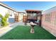 Private backyard with artificial turf, a covered patio, and charming decor at 6292 Yucca Valley Ct, Las Vegas, NV 89142