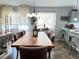 Open dining area with a wooden table, seating for eight, and large windows at 6292 Yucca Valley Ct, Las Vegas, NV 89142