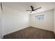 Bright bedroom featuring neutral carpet, base molding and a window with outdoor views and a ceiling fan at 716 Vincent Way, Las Vegas, NV 89145