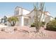 Desert landscaping complements this light-colored two story home with tile roofing at 7253 Alsop Ct, Las Vegas, NV 89156