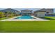 Expansive backyard featuring a pristine pool, outdoor kitchen, dining area, sport court and green lawn at 8528 Baltimore Heights Ct, Las Vegas, NV 89113