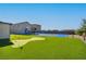An expansive backyard features a well-manicured lawn with a putting green and sports court for year-round outdoor activities at 8528 Baltimore Heights Ct, Las Vegas, NV 89113
