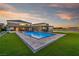 Backyard view featuring a large pool, outdoor kitchen, and sports court at dusk at 8528 Baltimore Heights Ct, Las Vegas, NV 89113