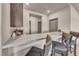 Modern bar area with light countertops and three chairs, perfect for entertaining guests at 8528 Baltimore Heights Ct, Las Vegas, NV 89113