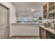 Bright bar area with sink, wood cabinets and pass-through to the large living room at 8528 Baltimore Heights Ct, Las Vegas, NV 89113