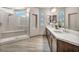 Modern bathroom with double sinks, walk-in shower, and tile floors at 8528 Baltimore Heights Ct, Las Vegas, NV 89113