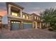 Elegant two-story home with a three-car garage, a balcony, a stone facade, and a spacious paved driveway at 8528 Baltimore Heights Ct, Las Vegas, NV 89113
