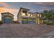 Elegant two-story home featuring a three-car garage, a balcony, a stone facade, and a spacious paved driveway at 8528 Baltimore Heights Ct, Las Vegas, NV 89113