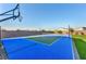 Private sports court with a basketball hoop and pickleball net, offering a convenient space for outdoor games and recreation at 8528 Baltimore Heights Ct, Las Vegas, NV 89113