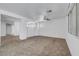 Spacious living room featuring neutral carpet, white walls and a ceiling fan providing comfort at 8529 Gold Flash Ave, Las Vegas, NV 89129