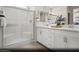 Modern bathroom featuring double sinks, sleek white cabinets, and a large glass-enclosed shower at 8683 Luxuriant Ave # Lot 26, Las Vegas, NV 89148