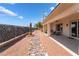 A spacious covered patio, rock landscaping, and privacy fence create a tranquil backyard retreat at 8824 Killians Greens Dr, Las Vegas, NV 89131