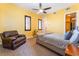 Bedroom with ceiling fan, yellow walls, shutters and a comfy arm chair at 8824 Killians Greens Dr, Las Vegas, NV 89131