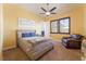 Bedroom with ceiling fan, shutters, comfortable chair, and neutral decor at 8824 Killians Greens Dr, Las Vegas, NV 89131