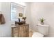 Stylish powder room featuring a decorative sink, vanity and mirror at 8824 Killians Greens Dr, Las Vegas, NV 89131