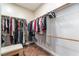 Walk-in closet with neatly organized clothes and bench at 8824 Killians Greens Dr, Las Vegas, NV 89131