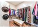 Walk-in closet with neatly organized clothes and hats, and a stylish bench at 8824 Killians Greens Dr, Las Vegas, NV 89131