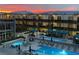 Beautiful pool area with seating and cabanas set against a backdrop of mountains and a colorful sunset at 8925 W Flamingo Rd # 319, Las Vegas, NV 89147