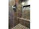 Contemporary shower featuring dark tiling, built-in bench and chrome fixtures at 8925 W Flamingo Rd # 319, Las Vegas, NV 89147