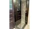 Modern shower with glass door, dark tile, and storage shelves at 8925 W Flamingo Rd # 319, Las Vegas, NV 89147