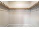 A simple walk-in closet with basic shelving and clothes rails for efficient storage at 9050 W Tropicana Ave # 1017, Las Vegas, NV 89147