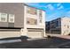 Modern townhome exterior featuring attached garages and multi-tone color scheme under a bright blue sky at 9050 W Tropicana Ave # 1017, Las Vegas, NV 89147
