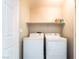 Well-lit laundry room featuring a washer, dryer and shelving for storage solutions at 9050 W Tropicana Ave # 1017, Las Vegas, NV 89147