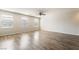 Bright living room with wood floors, abundant natural light from large windows, and a ceiling fan at 9050 W Tropicana Ave # 1017, Las Vegas, NV 89147