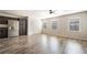 Open-concept living room with wood floors, large windows, and access to the kitchen at 9050 W Tropicana Ave # 1017, Las Vegas, NV 89147