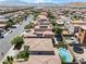 This is a high angle aerial view of a pool and trampoline in the backyards of neighboring homes at 9074 Iron Cactus Ave, Las Vegas, NV 89148