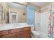 Bathroom with shower-tub combo, light blue shower curtain, white vanity, and mirror at 9074 Iron Cactus Ave, Las Vegas, NV 89148
