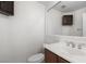 Small bathroom with toilet, sink, mirror and a dark brown cabinet at 9074 Iron Cactus Ave, Las Vegas, NV 89148