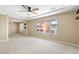 Bedroom featuring a carpeted floor, tray ceiling, and large window at 9074 Iron Cactus Ave, Las Vegas, NV 89148