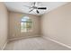 Bedroom featuring a neutral color palette, carpet, a ceiling fan, and an arched window at 9074 Iron Cactus Ave, Las Vegas, NV 89148