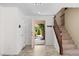 Bright foyer with tiled floors, staircase, and an open door leading to a lush front yard at 9074 Iron Cactus Ave, Las Vegas, NV 89148