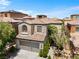 Two story home with a desert style landscape, symmetrical lines, and two car garage at 9074 Iron Cactus Ave, Las Vegas, NV 89148